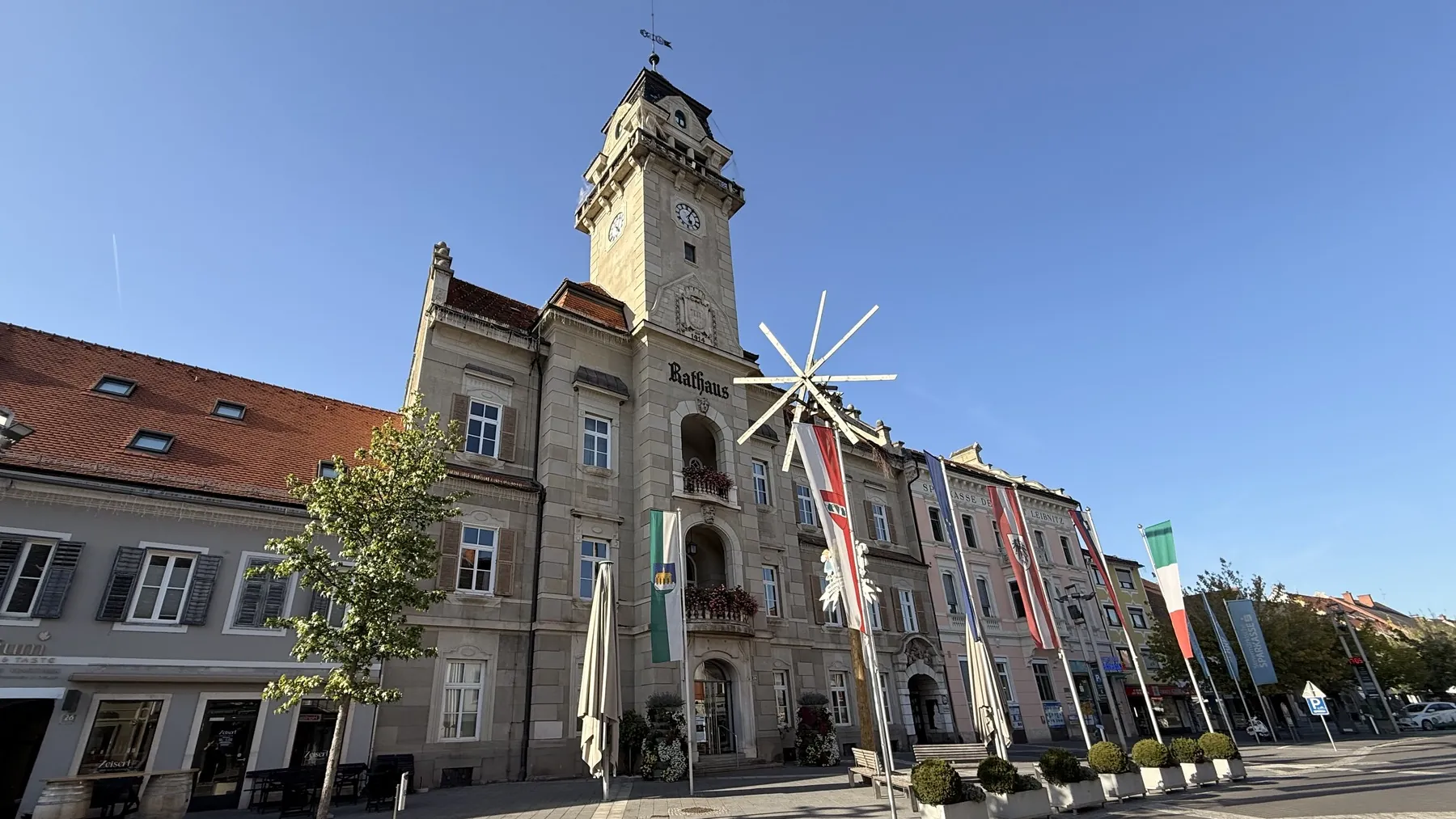 Rathaus Leibnitz am Hauptplatz mit Uhrturm und beflaggter Platzfront