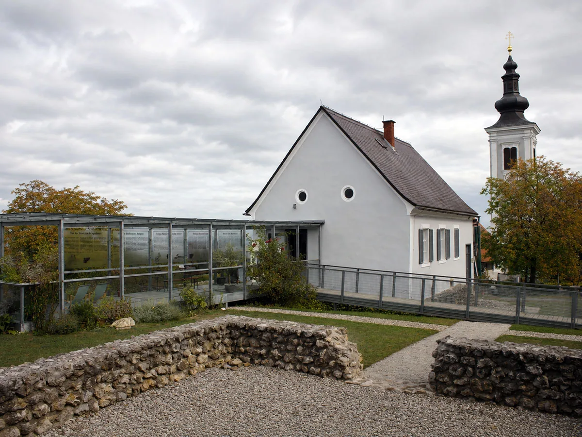 Tempelmuseum Frauenberg: Museumsgebäude, Glasüberdachung über den Grabungen und freigelegte Fundamente, dahinter der Turm der Wallfahrtskirche